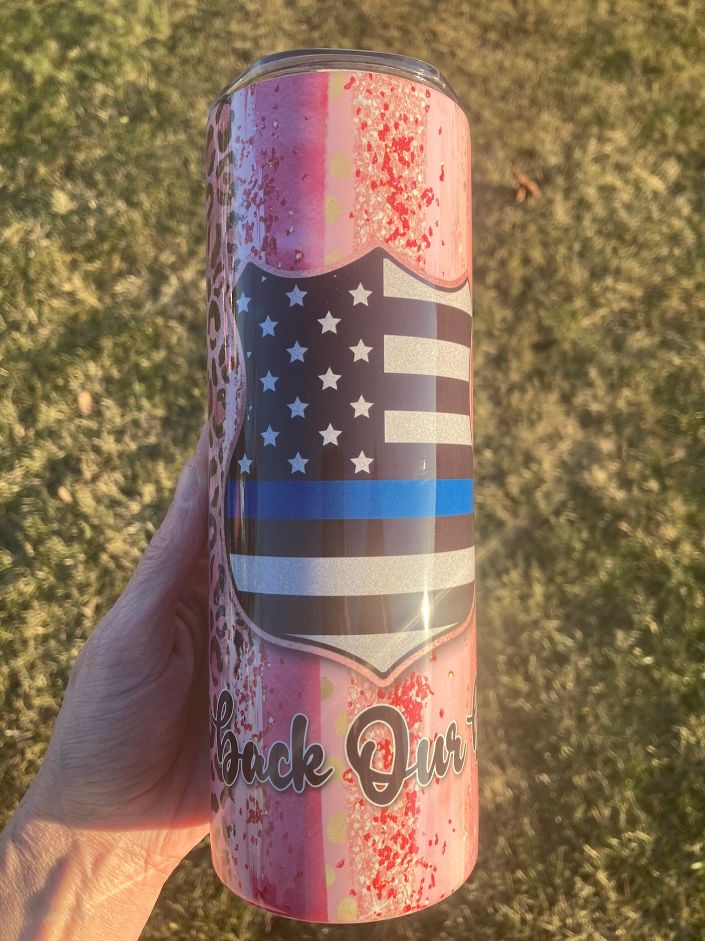 20oz skinny tumbler featuring thin blue line American flag with pink splatter background and “Back the Blue” design