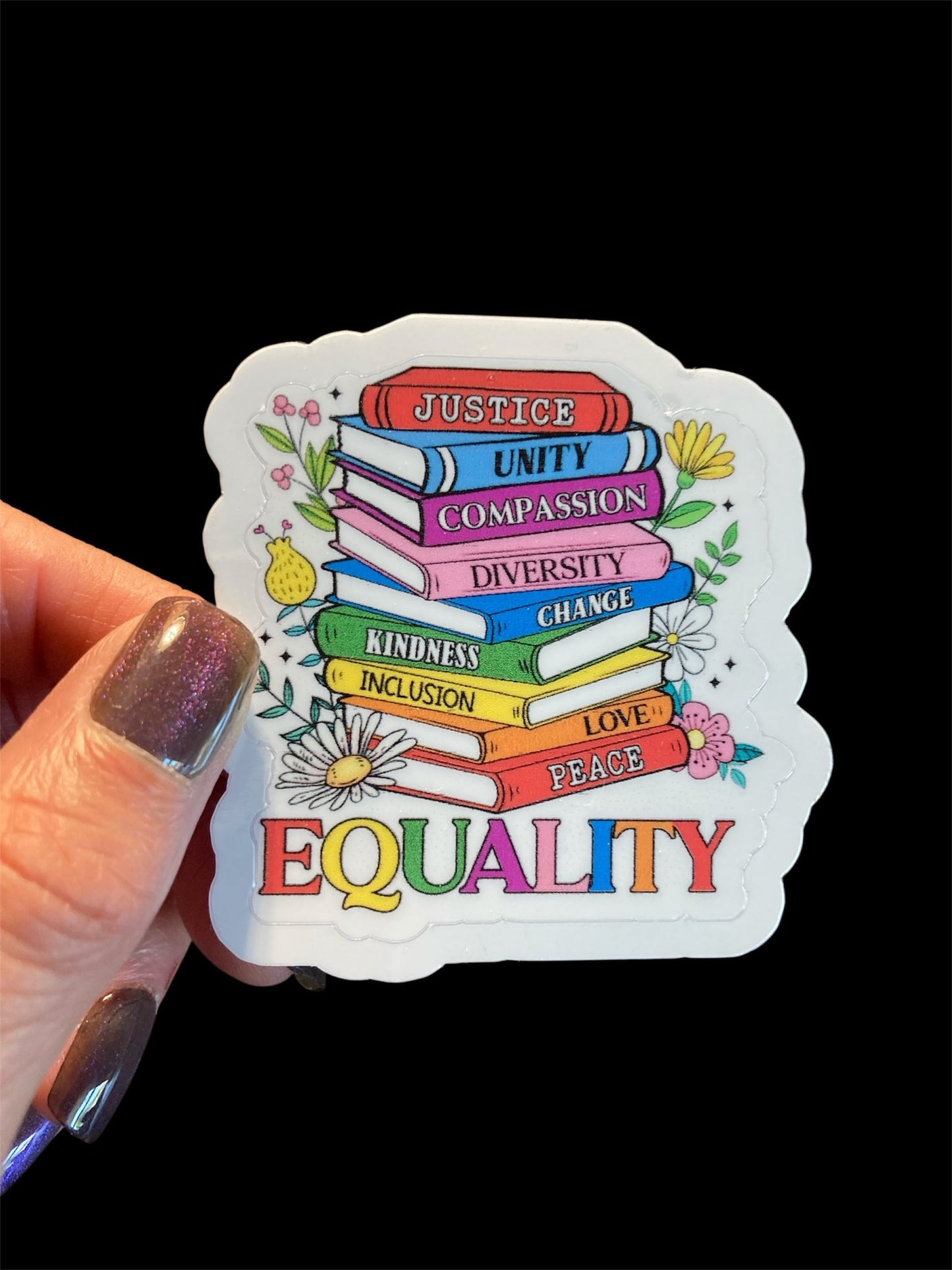 Sticker with motivational phrases and 'EQUALITY' in colorful text held by a hand.