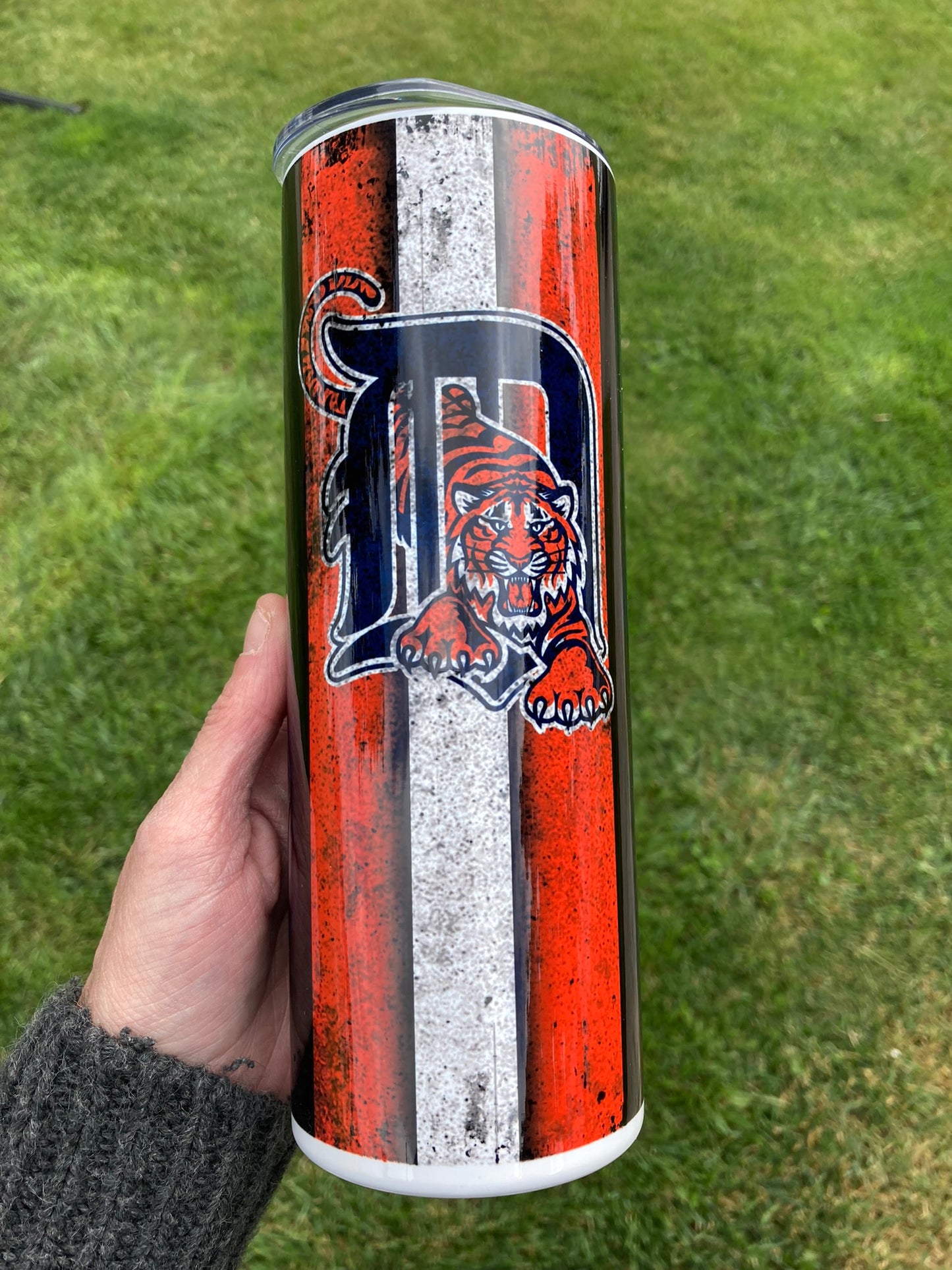 Tumbler with a tiger logo and 'D' on a grass background