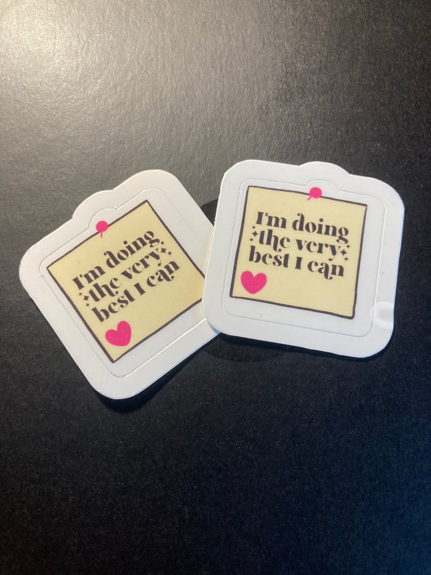 Two coasters with a motivational quote on a dark surface