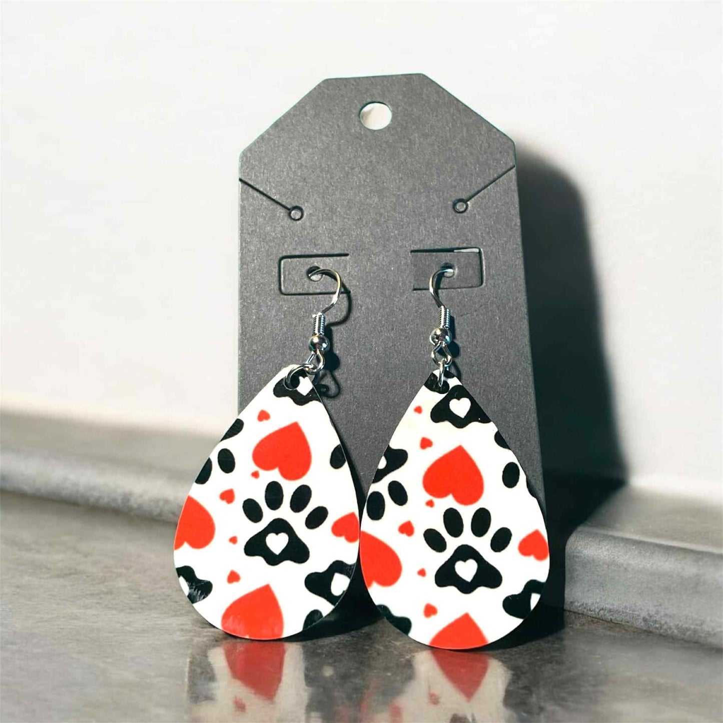 Lightweight teardrop earrings featuring black paw prints and red hearts on sublimation