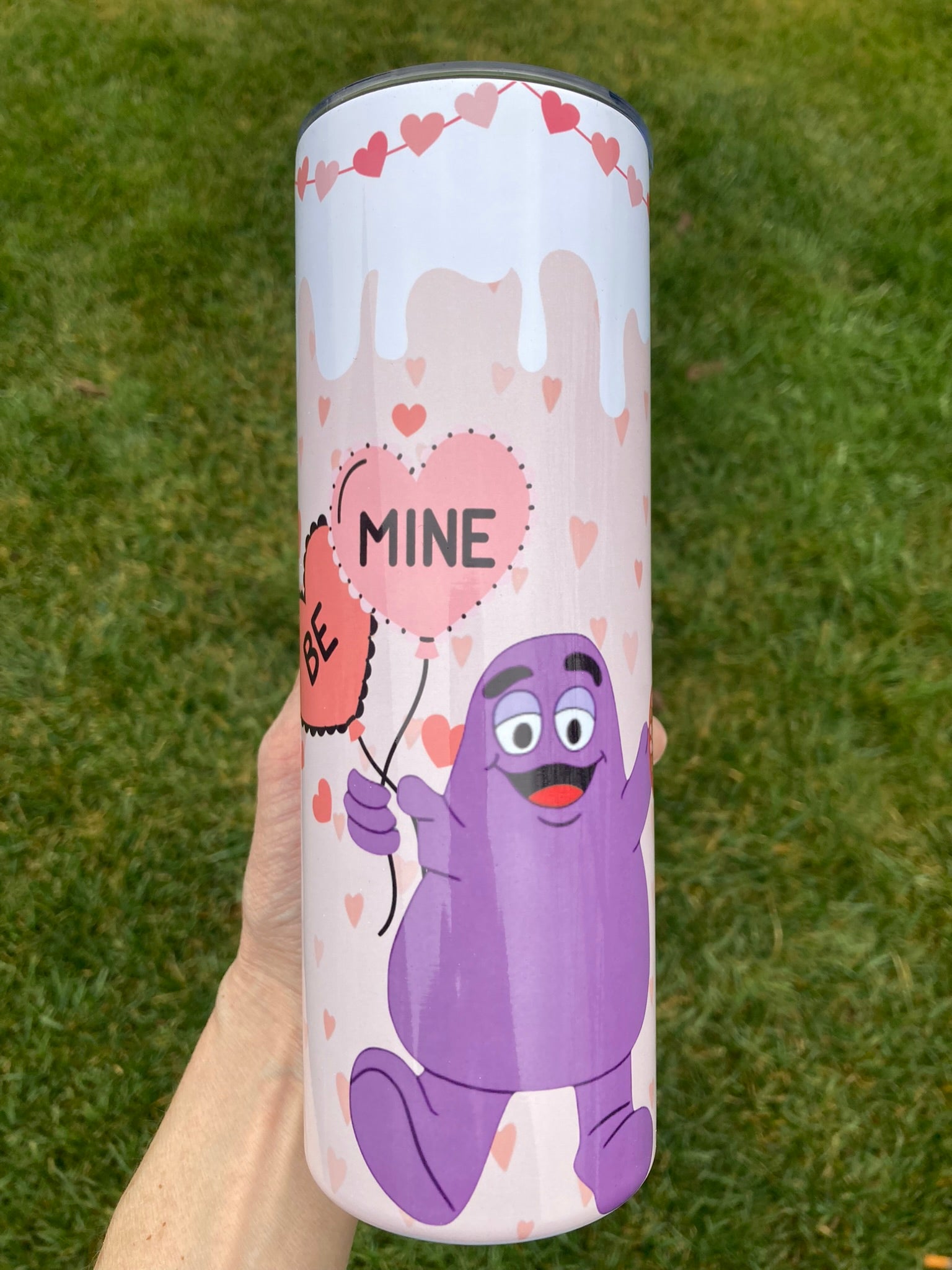 Purple cartoon (Grimace) character tumbler holding “Be Mine” hearts for Valentine theme