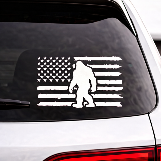 Bigfoot American flag vinyl car decal on rear window, white sasquatch silhouette with distressed USA flag design