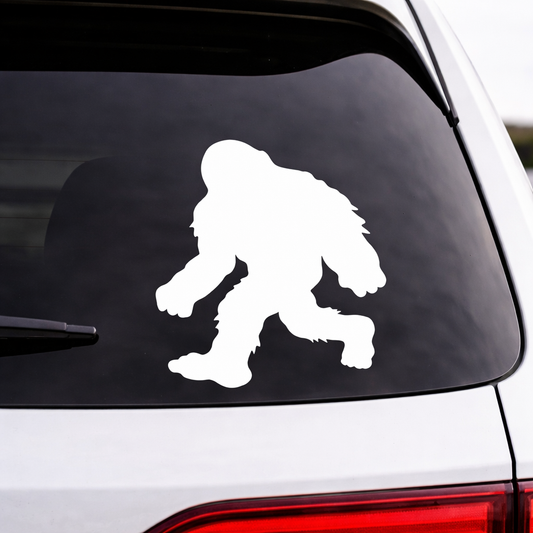 White Bigfoot silhouette decal on a car window. 