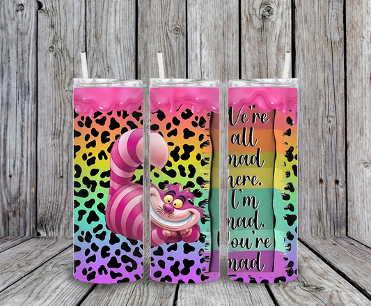 Cheshire Cat tumbler with rainbow leopard background, dripping pink glitter top, and quote “We’re all mad here, I’m mad, you’re mad.”
