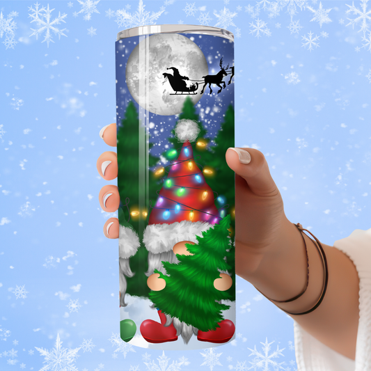 Tumbler with Christmas design featuring a gnome, tree, and sleigh against a snowy background