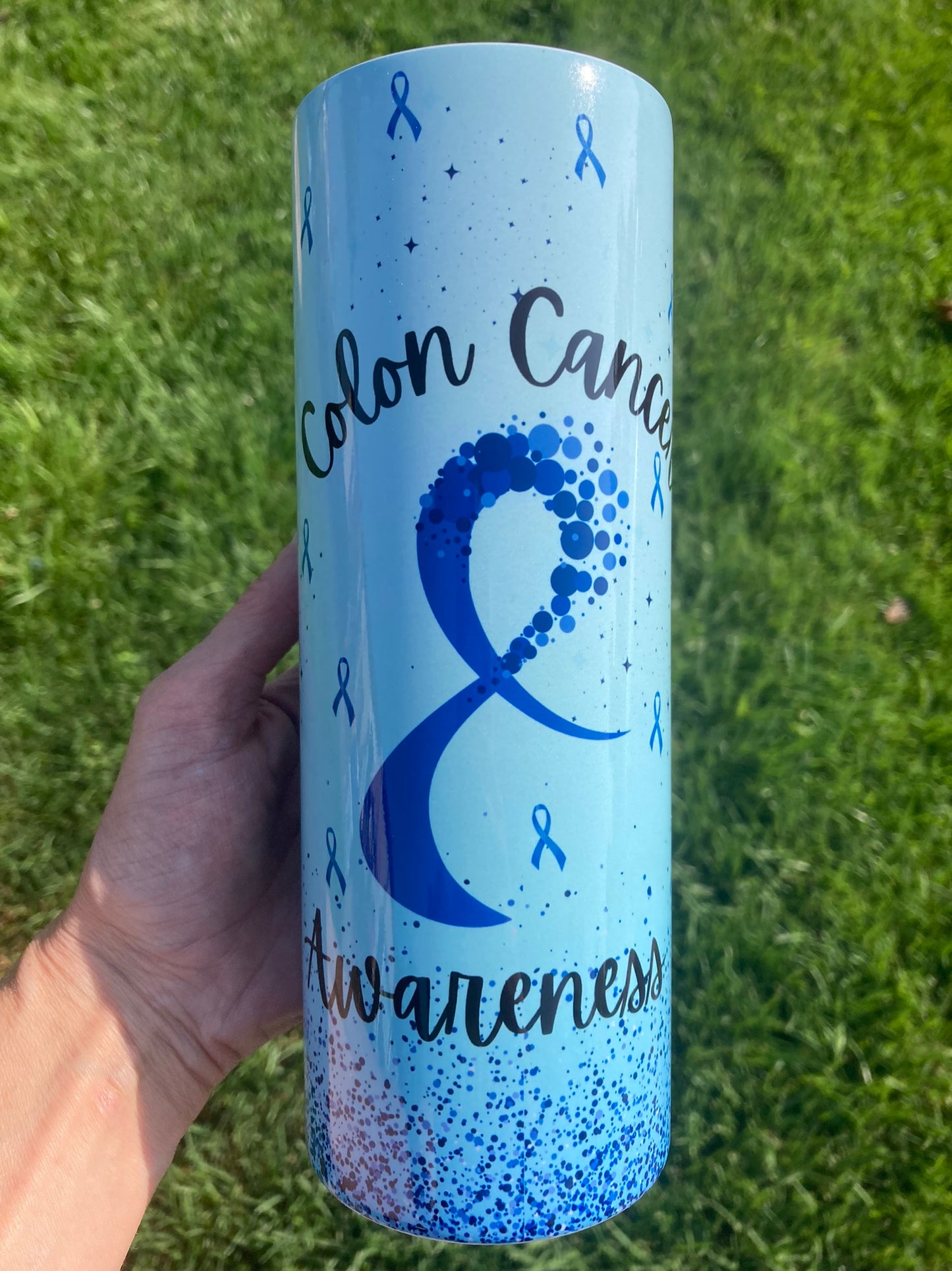 Light blue tumbler with colon cancer awareness ribbon, sparkles, and “Colon Cancer Awareness” message design