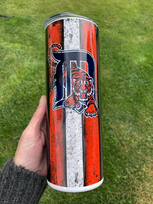 Tumbler with a tiger logo and 'D' on a grass background