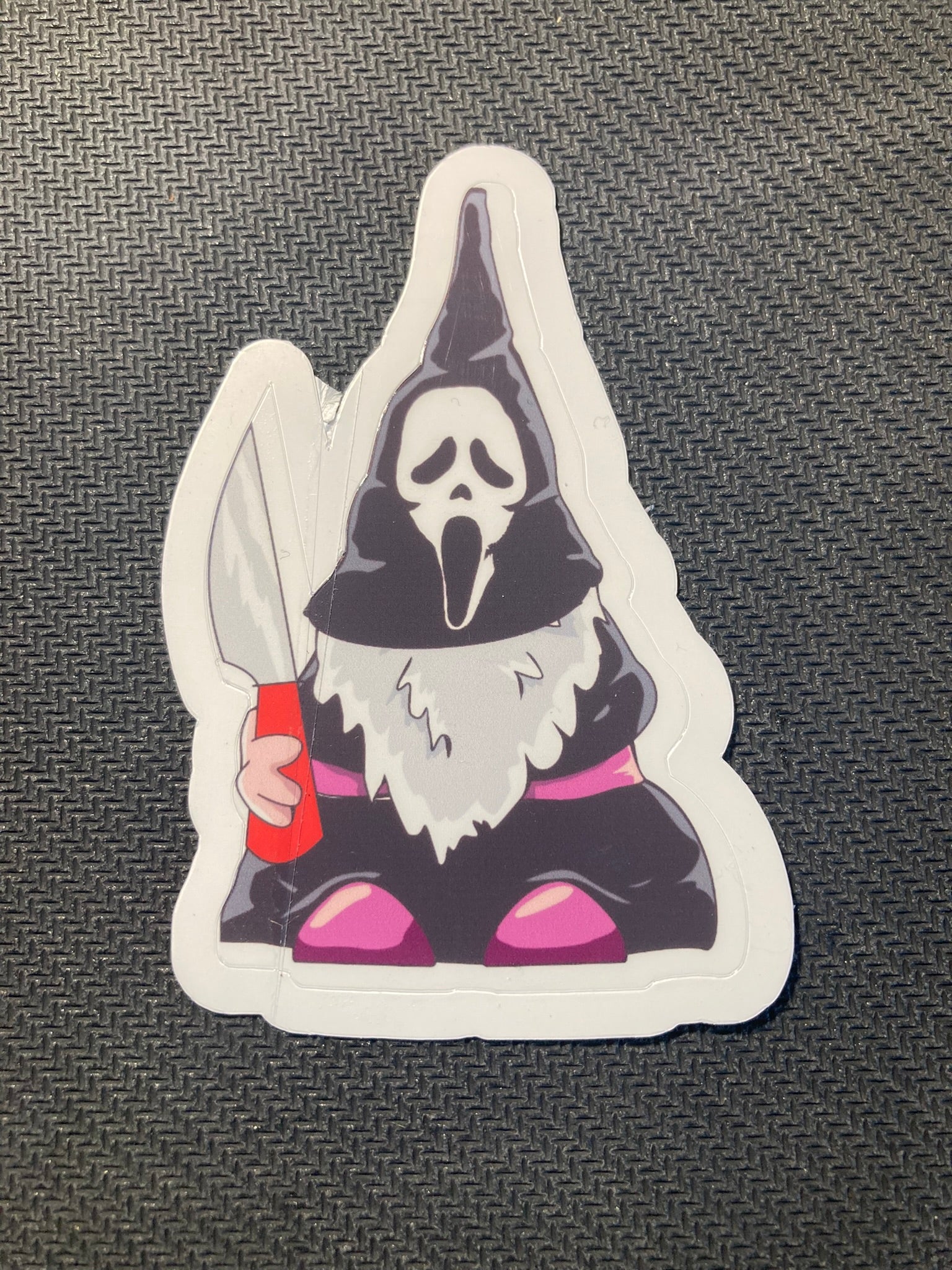 Halloween sticker of a gnome dressed as Ghostface with iconic mask and knife.