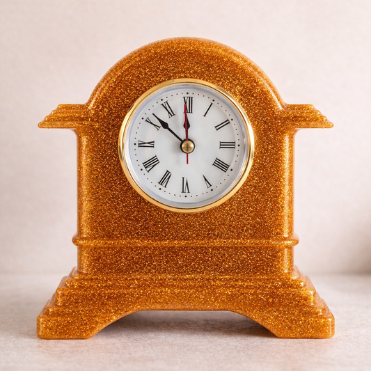 Decorative clock with a gold glittery casing on a light background