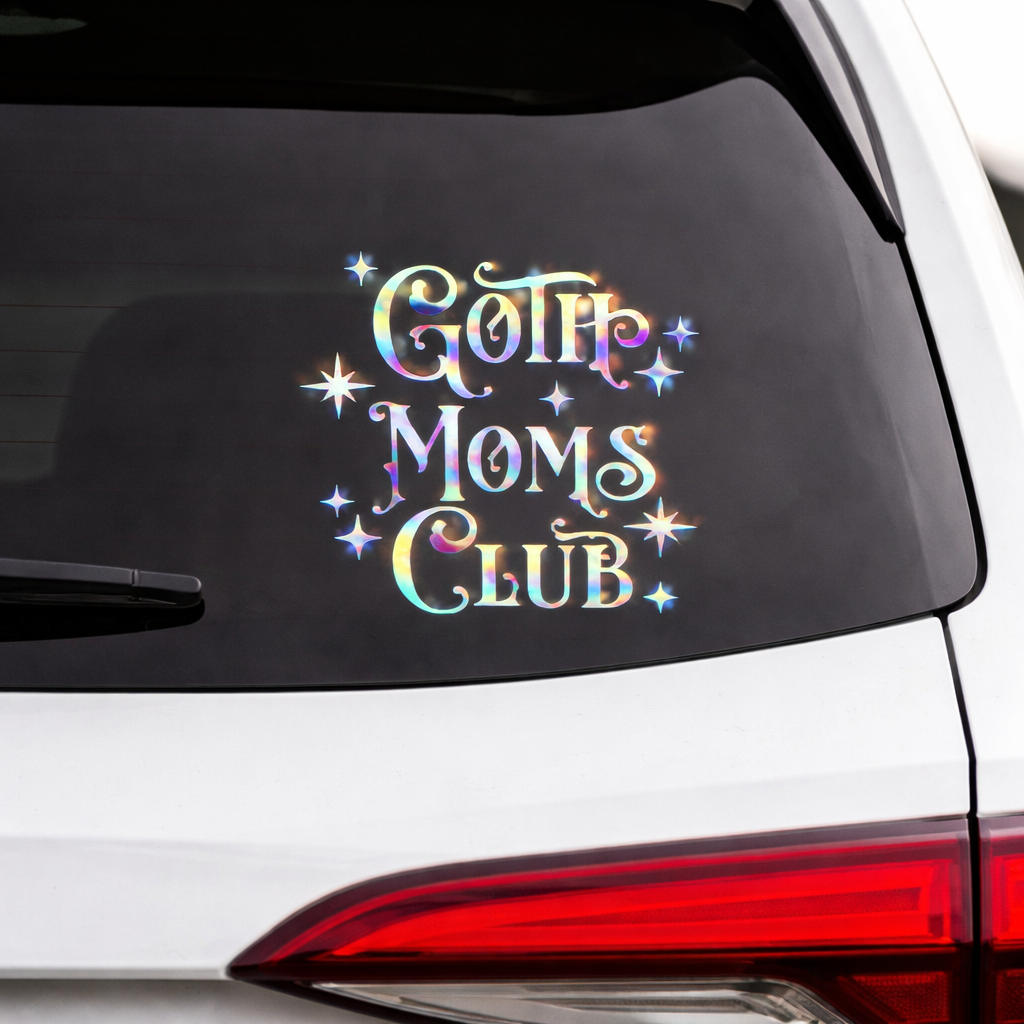 Car window with 'Goth Moms Club' decal featuring colorful text and stars.