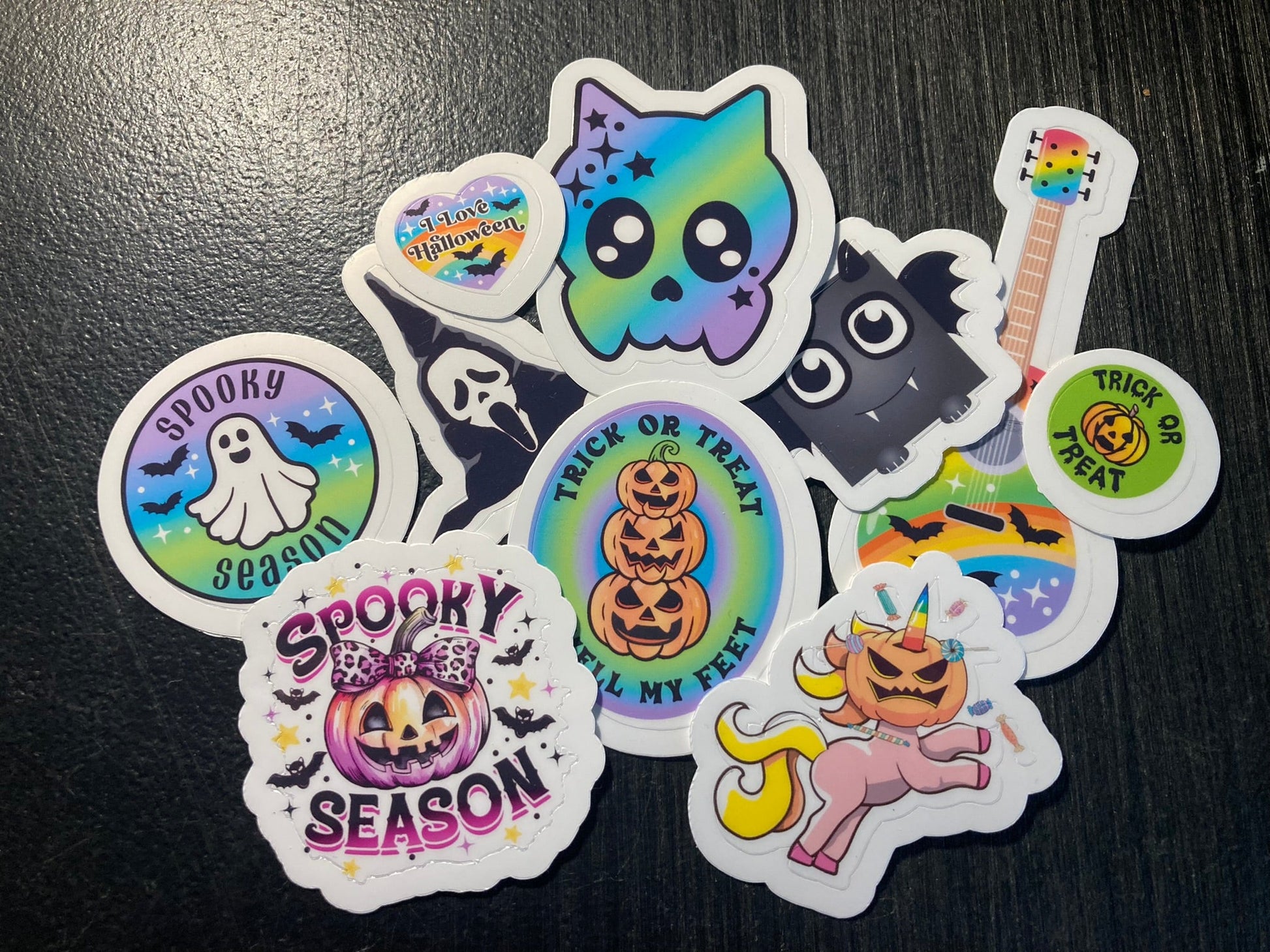 Set of colorful Halloween-themed stickers on a dark surface