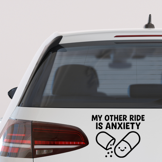 Black vinyl decal on a car window with text “My Other Ride Is Anxiety” and a cartoon pill graphic.