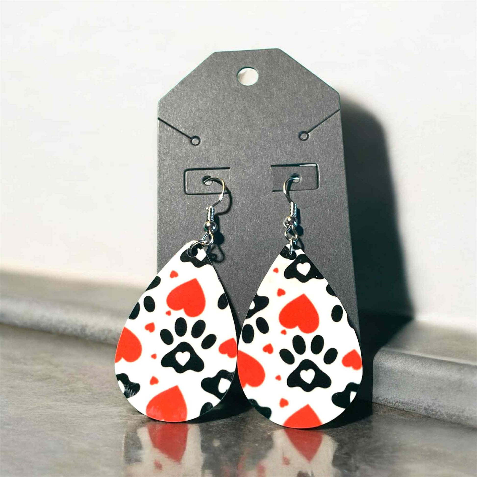 Lightweight teardrop earrings featuring black paw prints and red hearts on sublimation