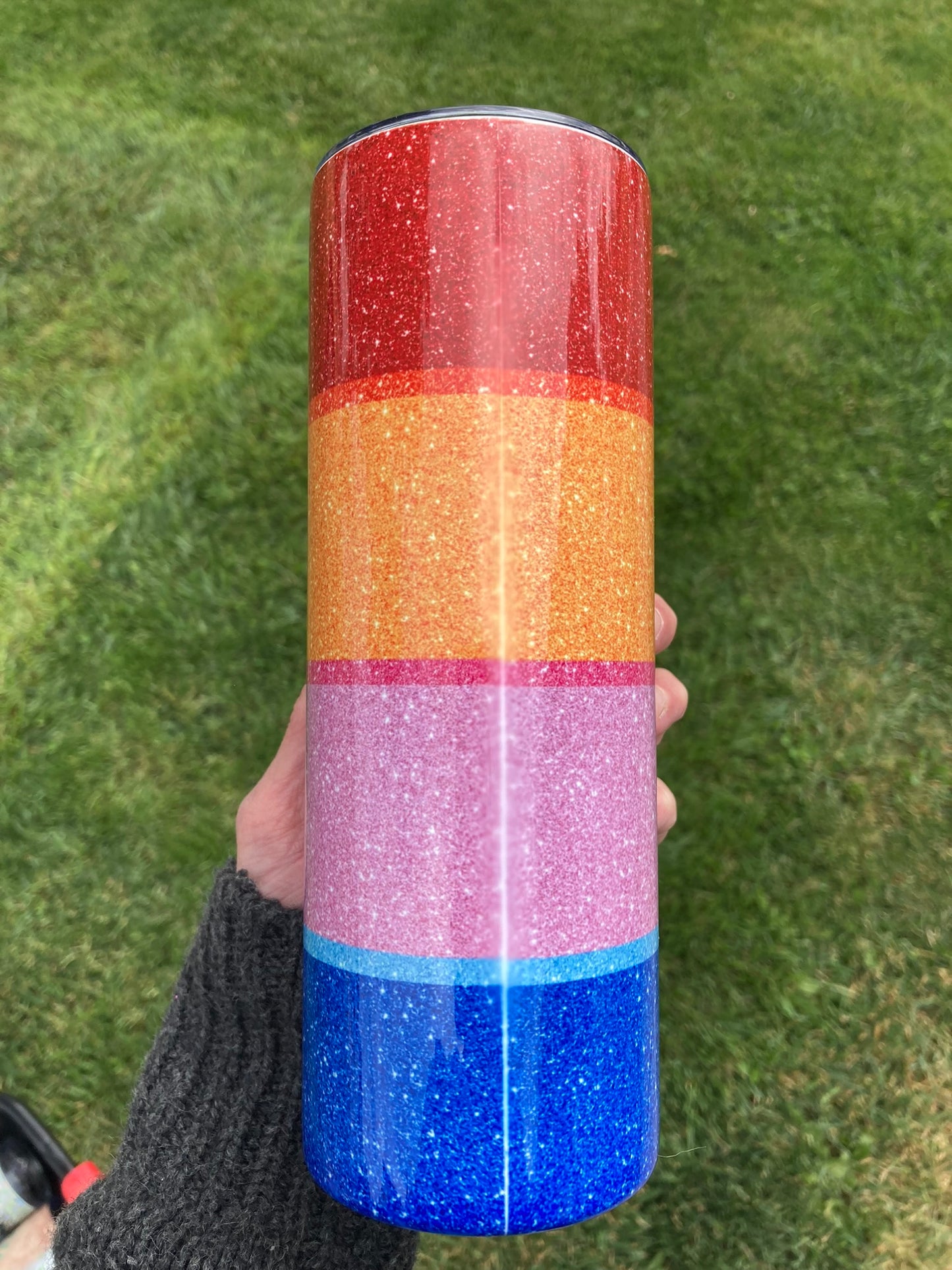 20oz tumbler featuring Winnie the Pooh, Tigger, Piglet, and Eeyore in a colorful glitter ombre design. Colorful glittery tumbler held against a grass background
