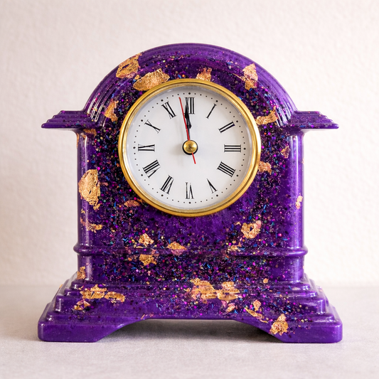 Purple decorative clock with gold accents on a light background