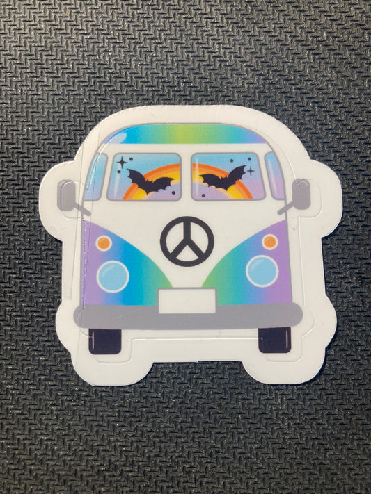 Halloween sticker of a colorful rainbow hippie van decorated with bats and peace sign on the front.