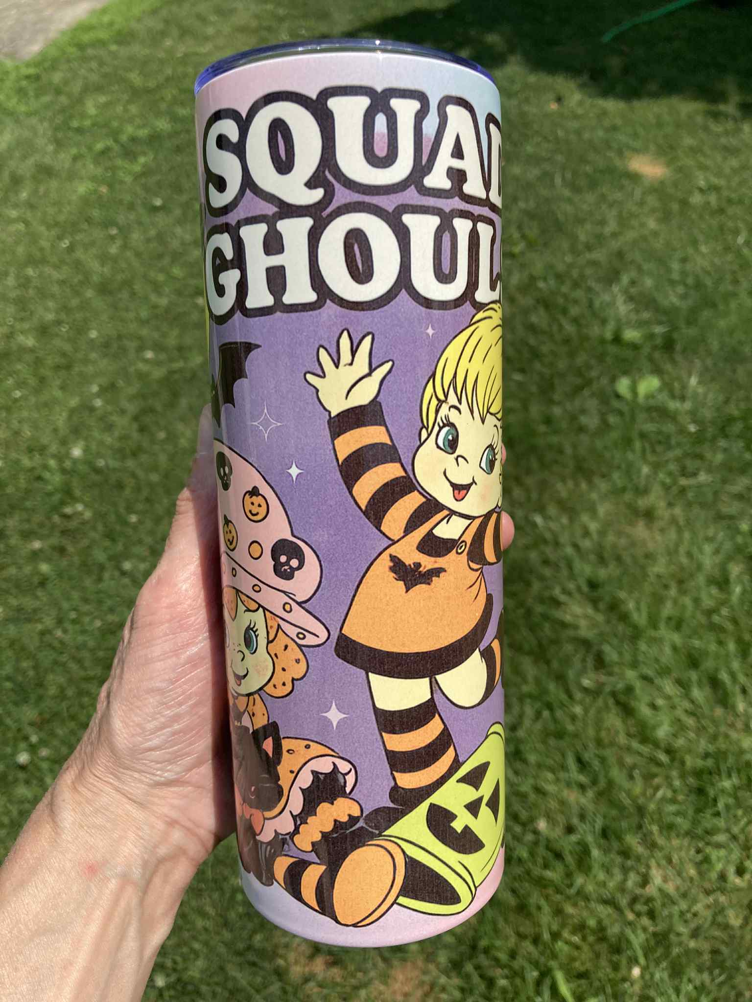 Tumbler with Halloween-themed design featuring a character and text on a grass background