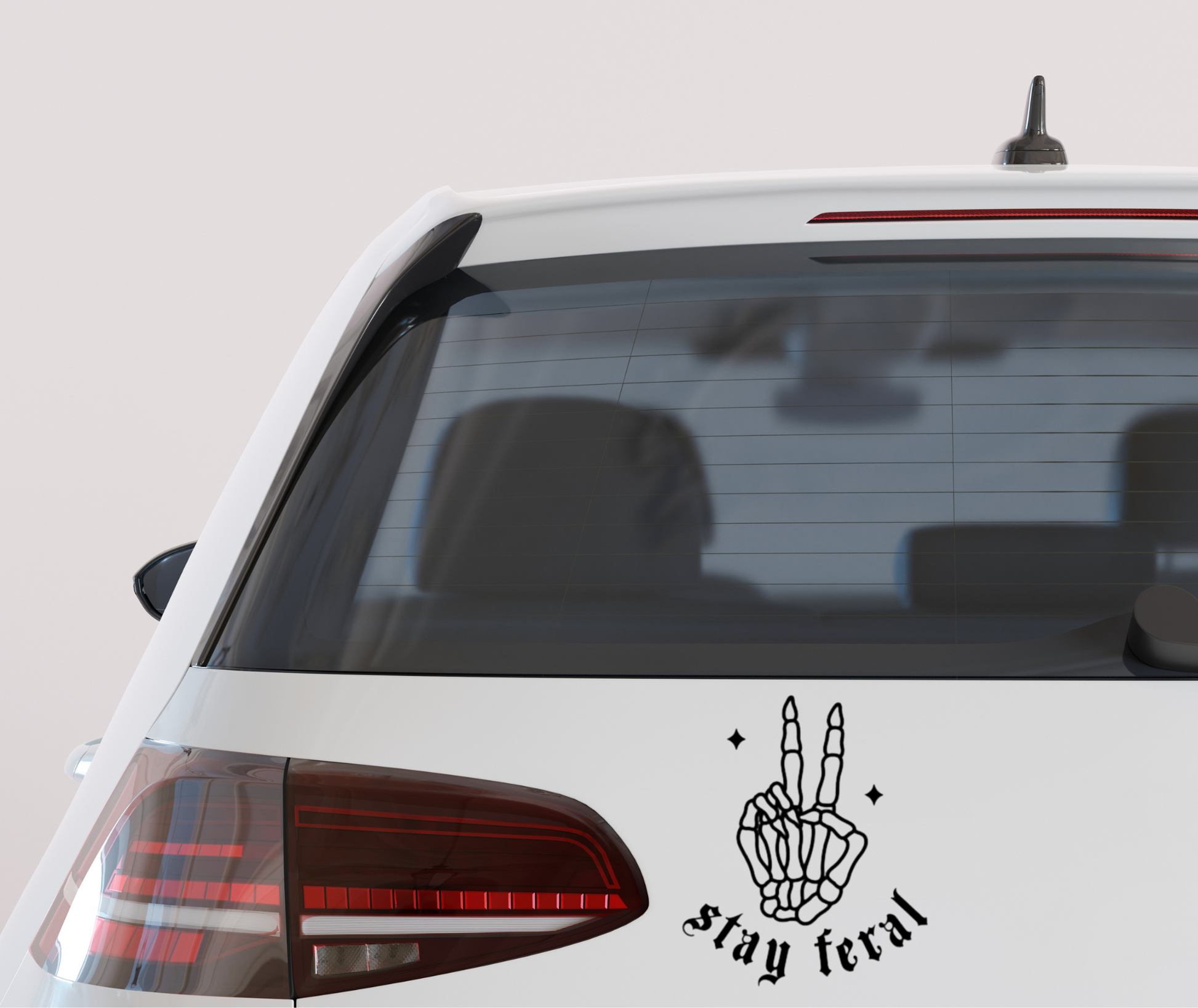 “Stay Feral” vinyl decal featuring a skeleton design, spooky gothic alternative sticker for cars, laptops, and water bottles.