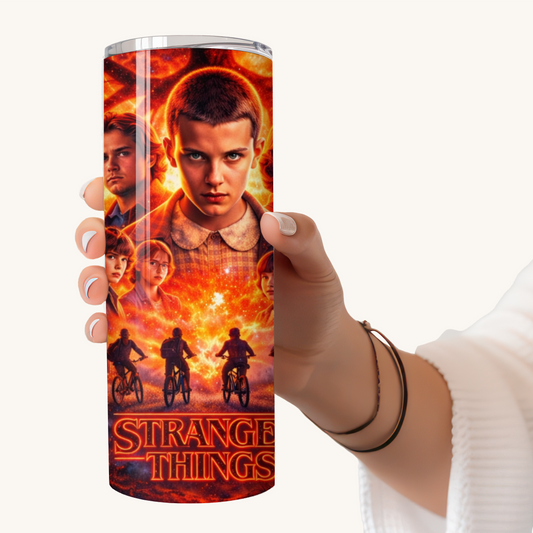 Hand holding a 20oz stainless steel tumbler featuring a Stranger Things–inspired cinematic Eleven design with retro sci-fi imagery and Upside Down themes.