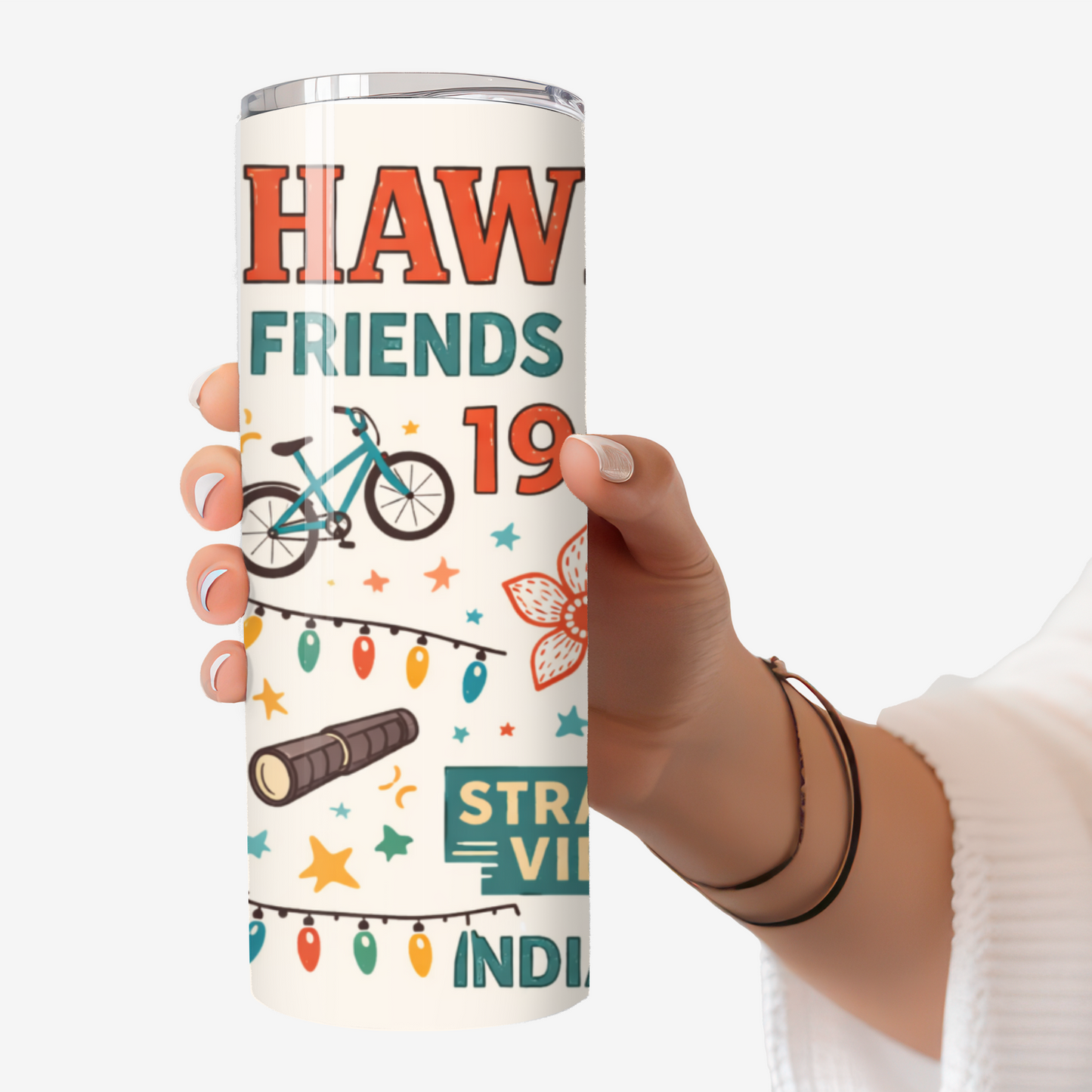 Hand holding a 20oz stainless steel tumbler featuring a Stranger Things–inspired “Friends Don’t Lie” design with retro icons, bikes, lights, and 80s details.