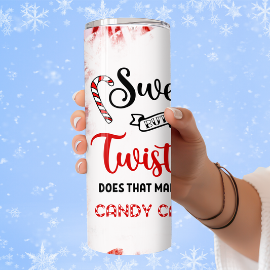 Tumbler with Christmas-themed text and candy cane design held by a hand against a snowy background