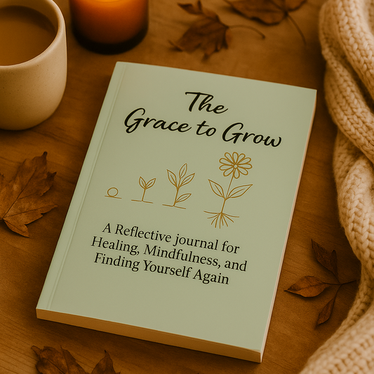 Book titled 'The Grace to Grow' on a wooden surface with a lit candle and cup of coffee.