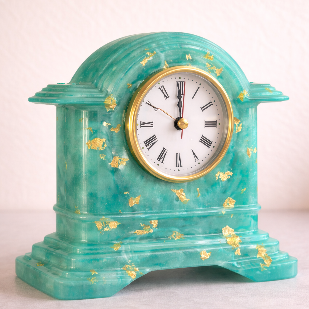 Turquoise clock with gold accents on a light pink background