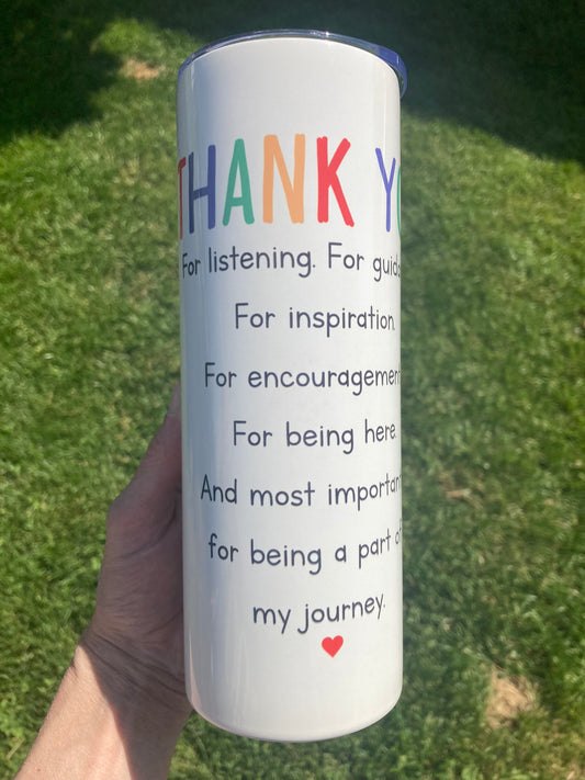 Tumbler with colorful text and a heart on a grassy background