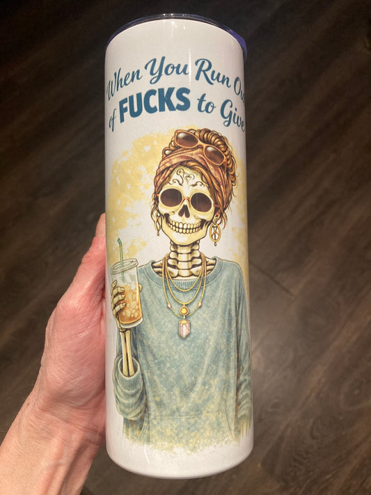 Skeleton woman holding iced coffee with “When You Run Out of Fucks to Give” text on a 20 oz sublimation tumbler.