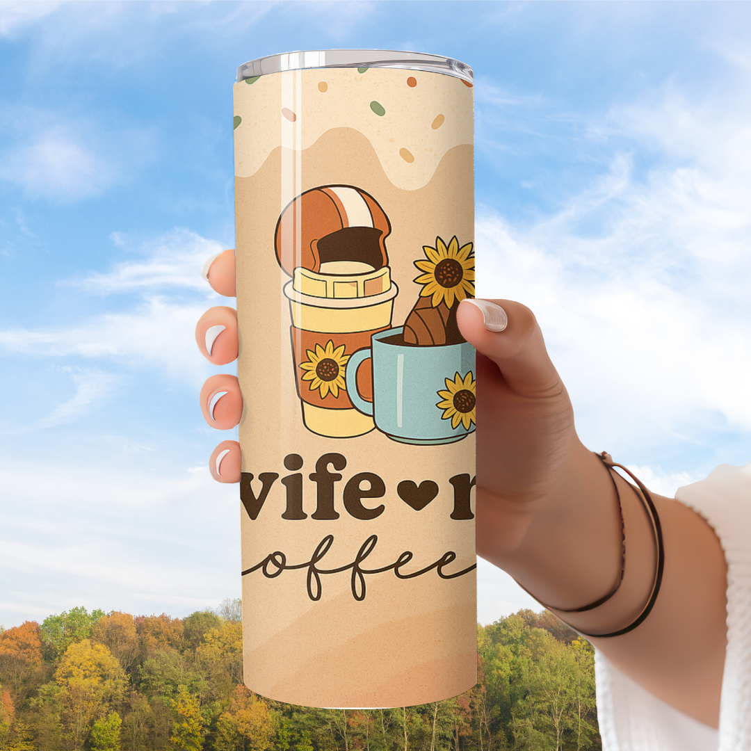 Tumbler with 'wife loves coffee' design held against a scenic background