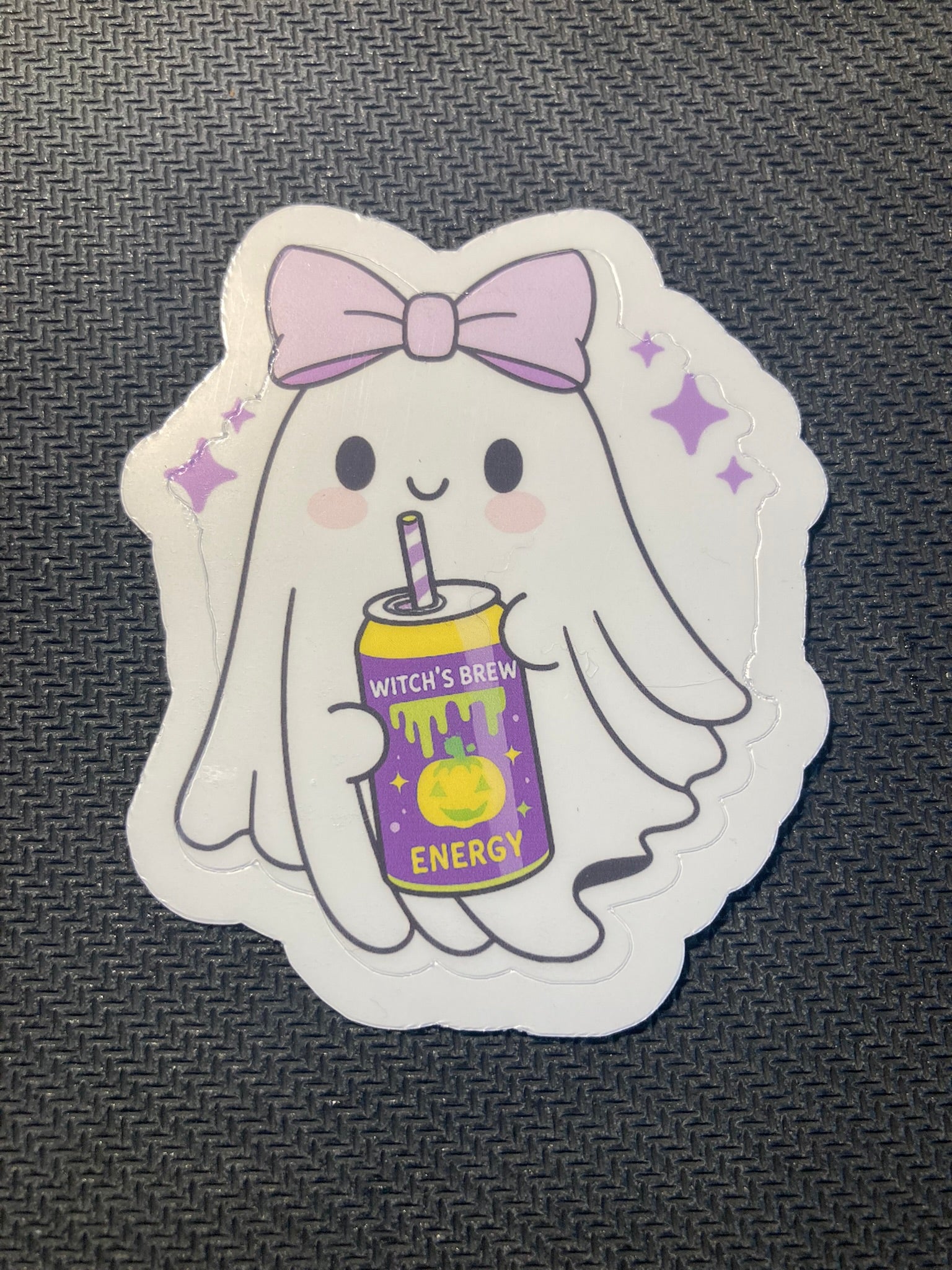 Cute ghost Halloween sticker holding a purple can labeled “Witch’s Brew Energy,” decorated with stars and a bow.