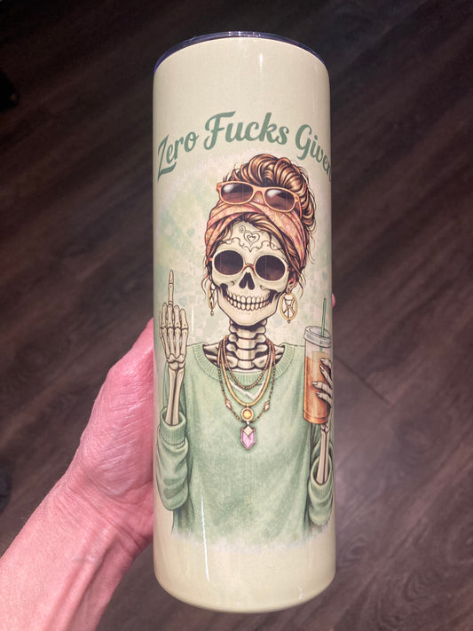 Skeleton woman holding iced coffee and raising a middle finger with “Zero Fucks Given” text on a 20 oz sublimation tumbler.