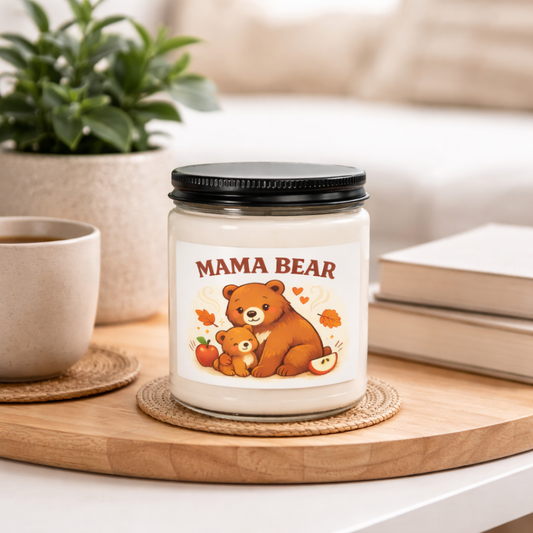 Candle with 'Mama Bear' label on a table with a cup and books in the background